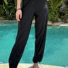 Full-length baggy swim pants with the leg opening tighteners closed for a secure fit while swimming.